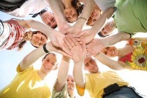 employees in circle holding hands out