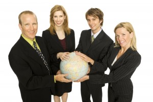 Four business people hold a globe together